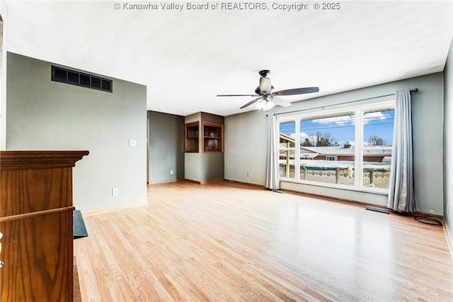 unfurnished living room featuring ceiling fan, baseboards, wood finished floors, and visible vents