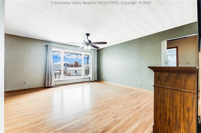 spare room with ceiling fan, baseboards, and wood finished floors