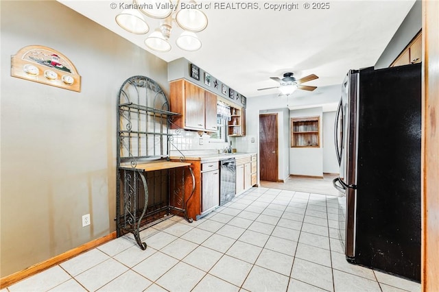 kitchen featuring light tile patterned flooring, freestanding refrigerator, ceiling fan with notable chandelier, dishwashing machine, and light countertops