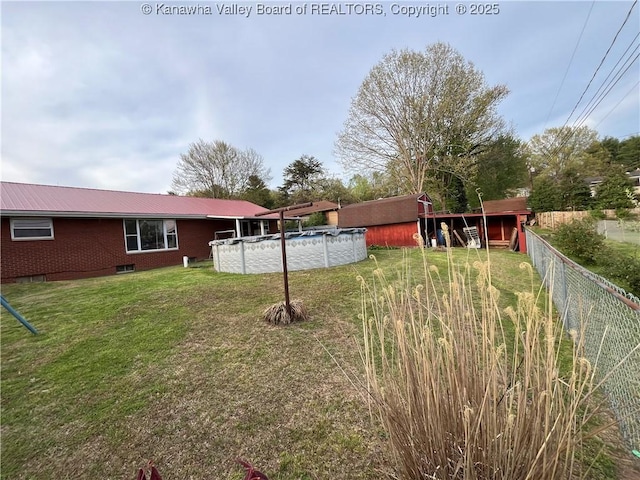 view of yard featuring fence and a covered pool