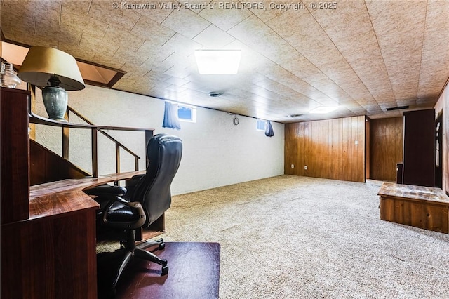 carpeted office space with wooden walls