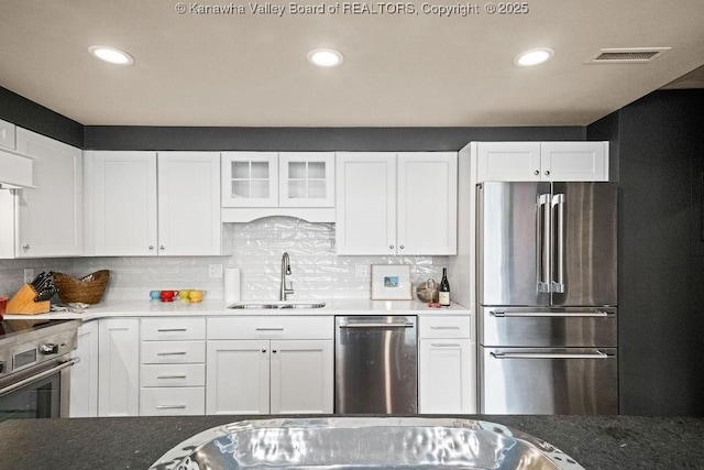 1578 Kanawha Blvd Unit 7C, Charleston, WV 25311 - kitchen featuring appliances with stainless steel finishes, a sink, white cabinetry, backsplash, and glass insert cabinets
