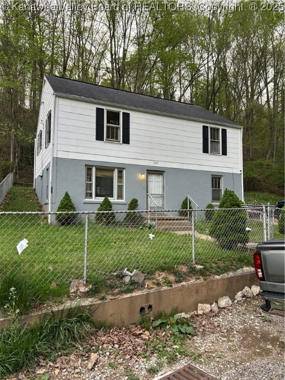 view of front facade featuring a front yard, fence private yard, and stucco siding