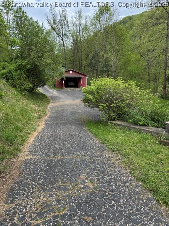 12376 Elk River Rd N, Clendenin, WV 25045 - view of front of home with a wooded view, driveway, and an outbuilding