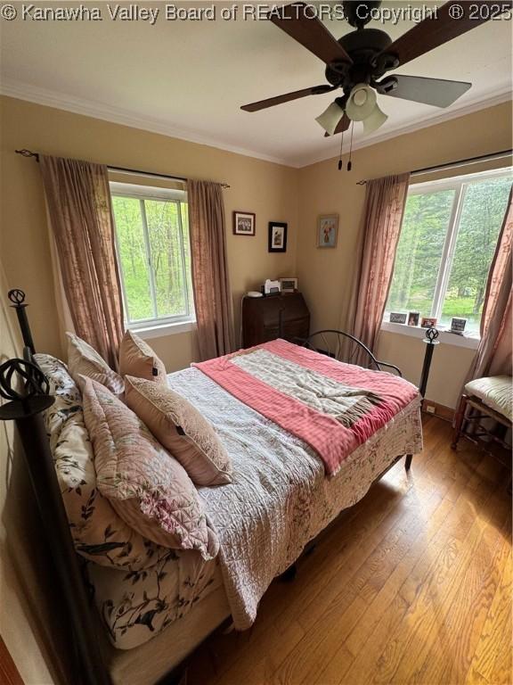 12376 Elk River Rd N, Clendenin, WV 25045 - bedroom featuring multiple windows, wood finished floors, crown molding, ceiling fan, and baseboards