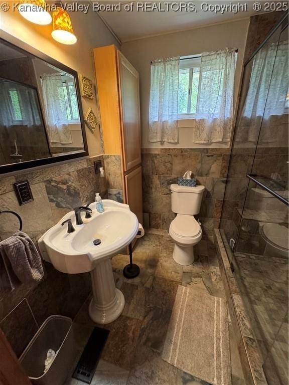 12376 Elk River Rd N, Clendenin, WV 25045 - full bathroom featuring tile walls, toilet, a stall shower, a wainscoted wall, and a sink