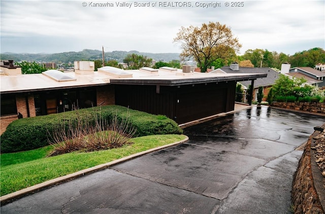 207 Mckinley Ave, Charleston, WV 25314 - exterior space featuring brick siding, an attached garage, and a chimney