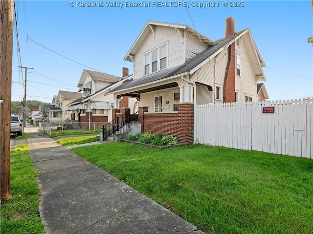 54 Hunt Ave, Charleston, WV 25302 - view of front facade featuring a chimney, a porch, brick siding, fence, and a front lawn