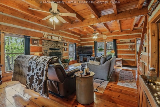 78 Cougar Mountain Dr, Winfield, WV 25213 - living area featuring a fireplace, wooden walls, plenty of natural light, and a ceiling fan