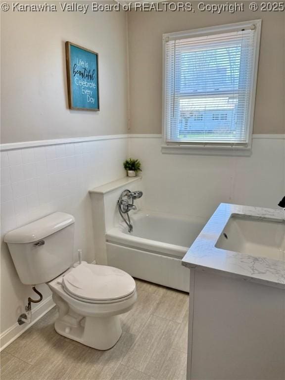full bath featuring wainscoting, toilet, a garden tub, and vanity