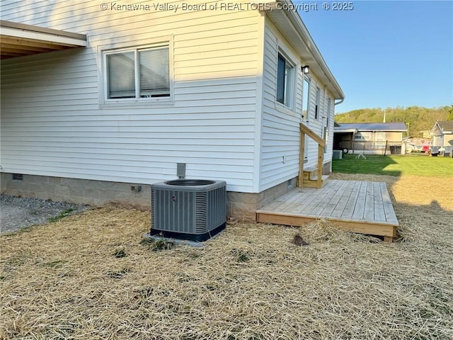 view of side of property with crawl space, central air condition unit, and a yard