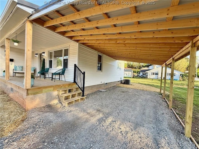 view of patio with a carport, central AC, and driveway