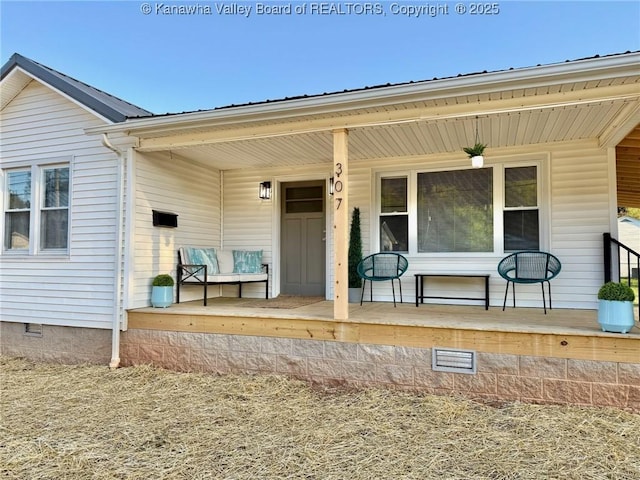 rear view of property featuring a porch and crawl space