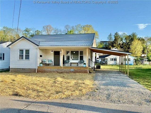 view of front of home with a front lawn, crawl space, metal roof, covered porch, and gravel driveway