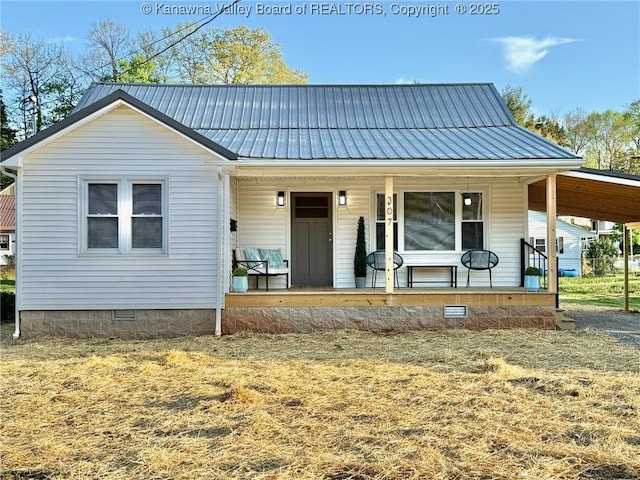 view of front of property with covered porch, a carport, metal roof, and crawl space