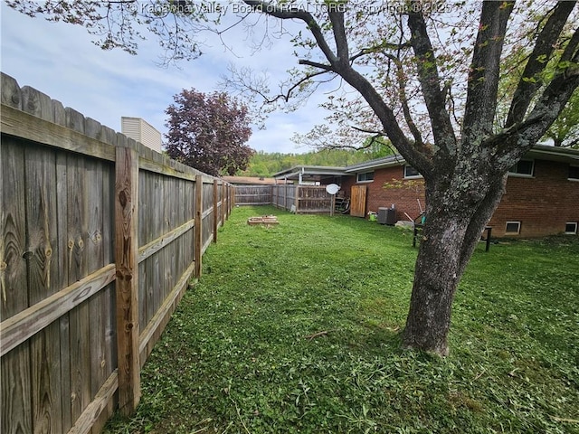 view of yard featuring a fenced backyard and central air condition unit
