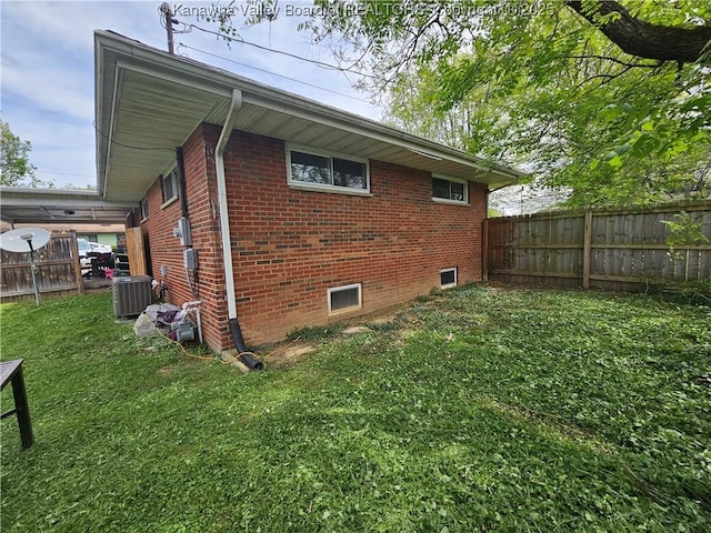 view of property exterior featuring brick siding, a fenced backyard, cooling unit, and a lawn