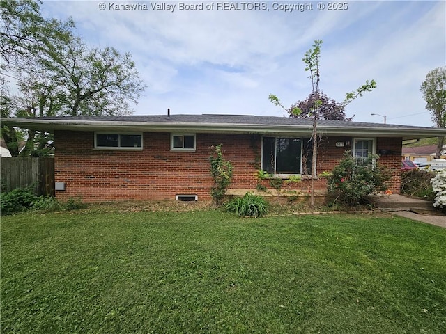 back of house with a lawn, fence, and brick siding