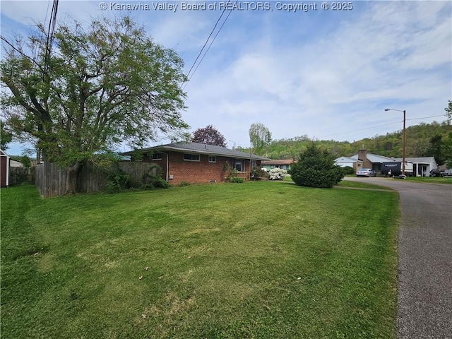 view of yard with fence and driveway