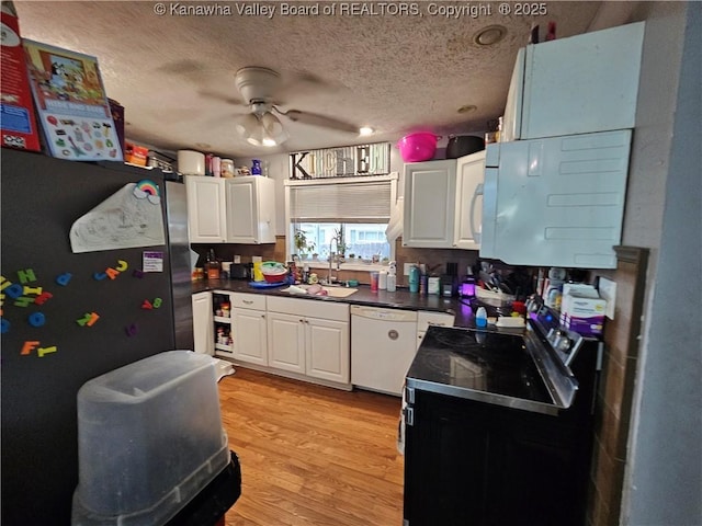kitchen with a textured ceiling, white cabinetry, dishwasher, and a sink