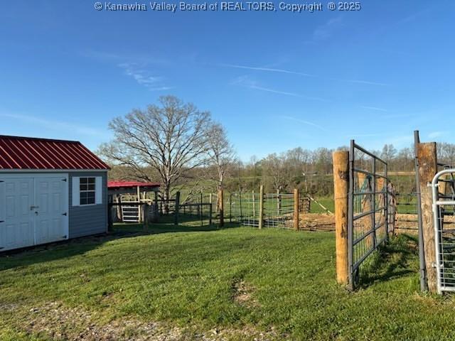 view of yard with fence, an outdoor structure, and a shed