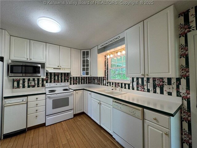 168 Jane Dr, Culloden, WV 25510 - kitchen with white appliances, light wood-style flooring, a sink, white cabinetry, and a textured ceiling