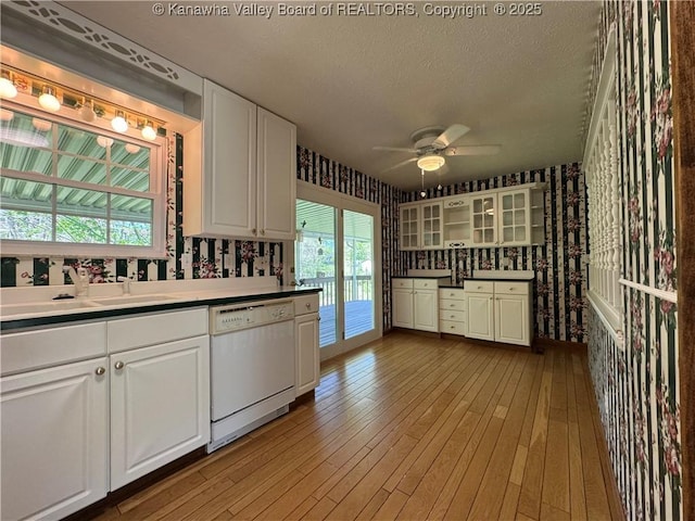 168 Jane Dr, Culloden, WV 25510 - kitchen featuring a sink, glass insert cabinets, a ceiling fan, dishwasher, and wallpapered walls