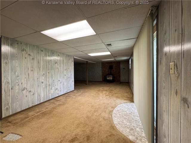 168 Jane Dr, Culloden, WV 25510 - finished basement with carpet flooring, a wood stove, wood walls, visible vents, and a paneled ceiling