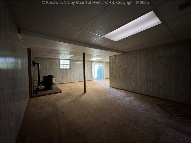 168 Jane Dr, Culloden, WV 25510 - basement featuring carpet, wooden walls, a paneled ceiling, and a wood stove