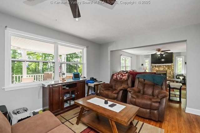 901 Evanwood Rd, Charleston, WV 25314 - living room with a ceiling fan, light wood-type flooring, a stone fireplace, and baseboards