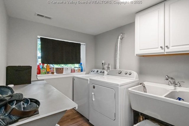 901 Evanwood Rd, Charleston, WV 25314 - laundry room featuring washing machine and clothes dryer, cabinet space, and wood finished floors