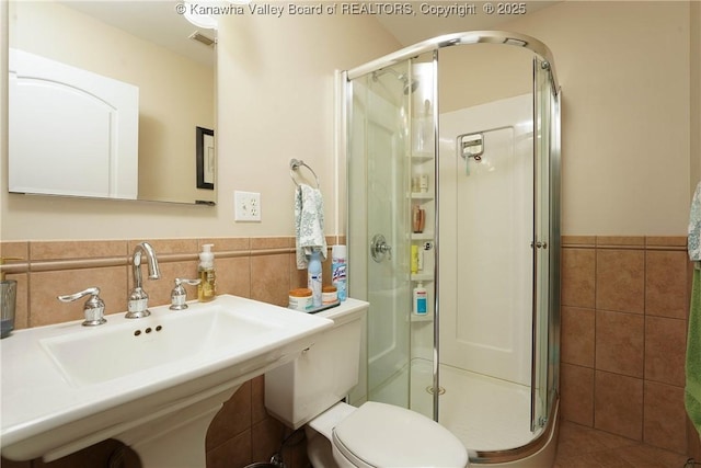 219 Deerhaven Ln, Cross Lanes, WV 25313 - bathroom with wainscoting, a sink, a stall shower, and tile walls