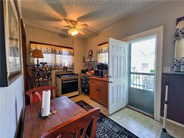 dining room featuring light floors, a ceiling fan, and a wealth of natural light