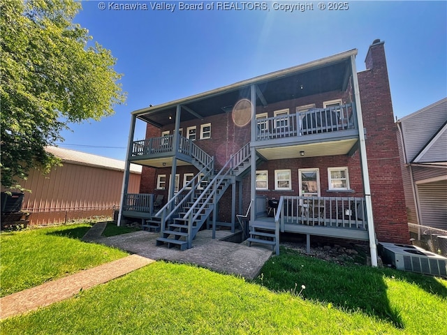 back of property with a wooden deck, central air condition unit, brick siding, stairway, and a yard