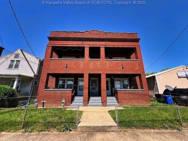 view of front of house featuring a front lawn, brick siding, a porch, a balcony, and fence private yard