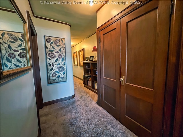 corridor with baseboards and carpet