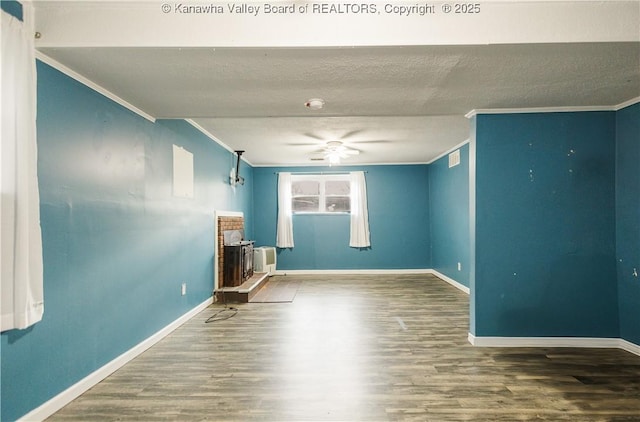 spare room featuring crown molding, wood finished floors, baseboards, ceiling fan, and a textured ceiling