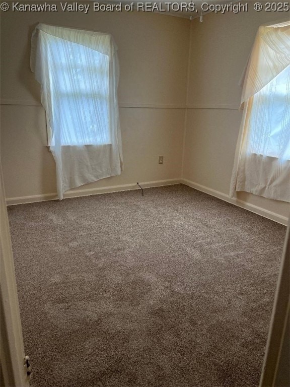 carpeted spare room featuring baseboards
