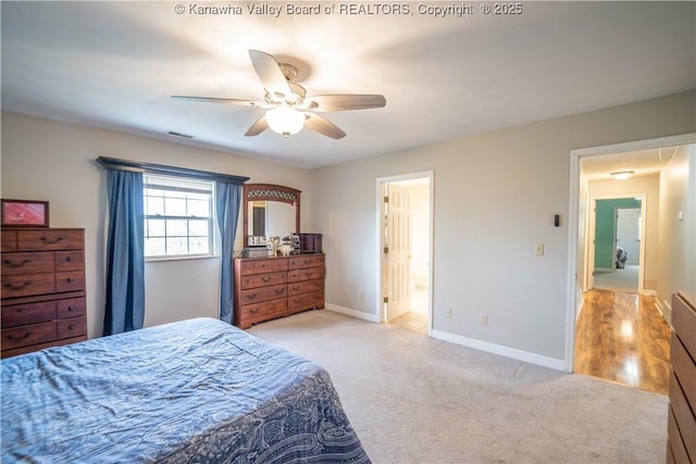 bedroom with light colored carpet, baseboards, a ceiling fan, and connected bathroom