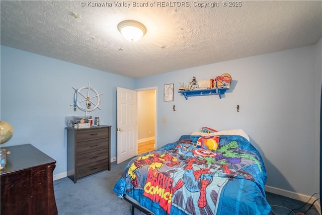 carpeted bedroom featuring a textured ceiling and baseboards