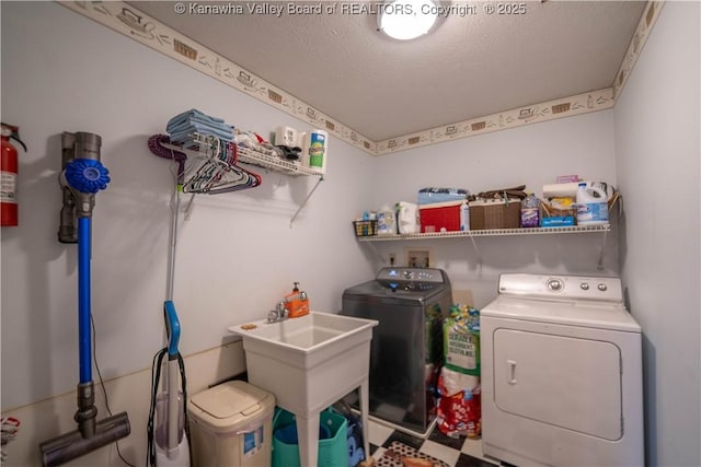 washroom featuring washer and dryer and a textured ceiling