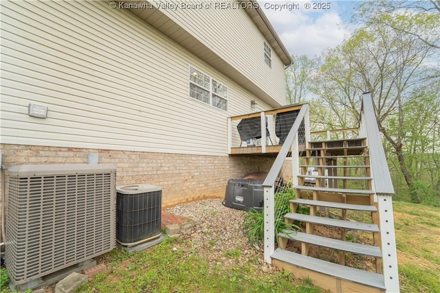 view of side of property featuring stairs, central air condition unit, and a deck