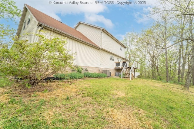 view of side of home featuring stairway, central air condition unit, a deck, and a lawn