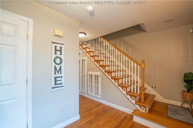 stairs with hardwood / wood-style flooring and baseboards