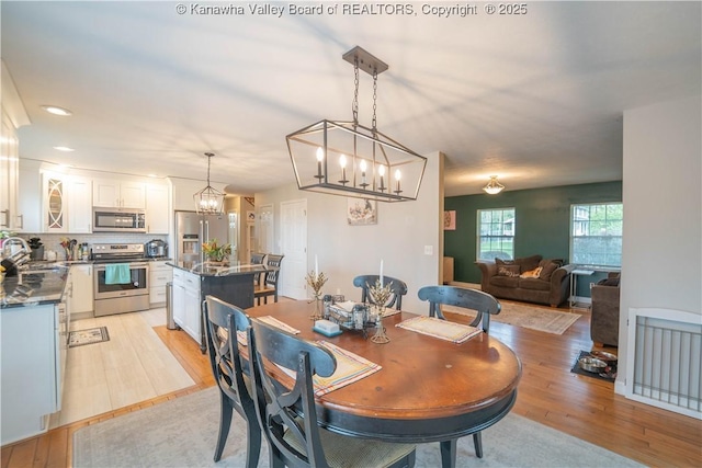 dining space with a chandelier and light wood-style floors