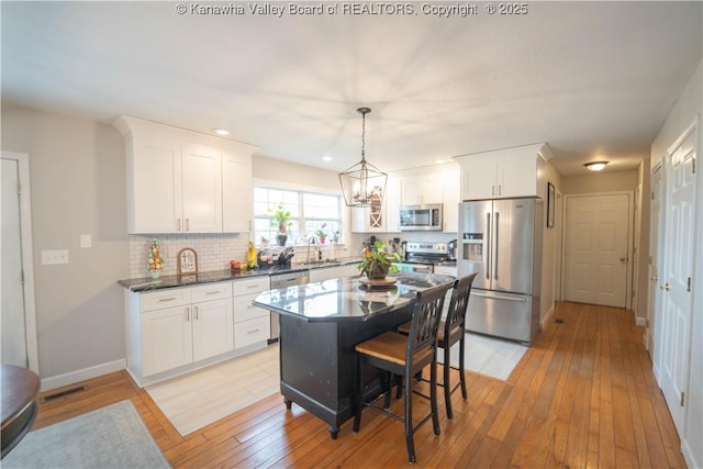 kitchen featuring appliances with stainless steel finishes, backsplash, white cabinets, and recessed lighting