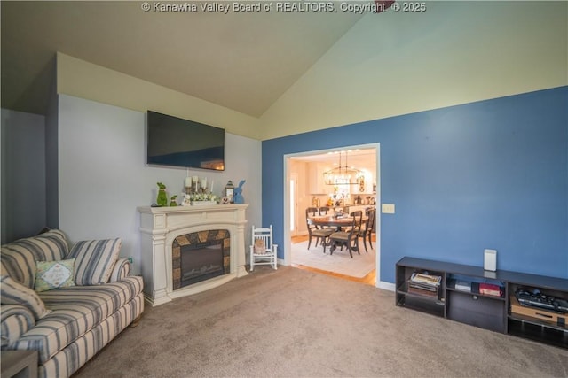 living area featuring a chandelier, vaulted ceiling, carpet, and a fireplace