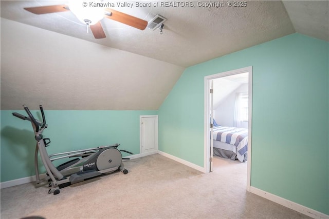 exercise area with lofted ceiling, ceiling fan, carpet flooring, and baseboards
