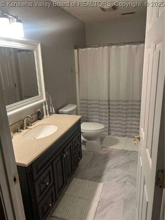 bathroom with marble look tile flooring, vanity, toilet, and a shower with shower curtain