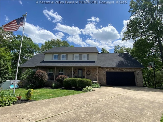 traditional home featuring concrete driveway, a garage, a front lawn, brick siding, and a porch